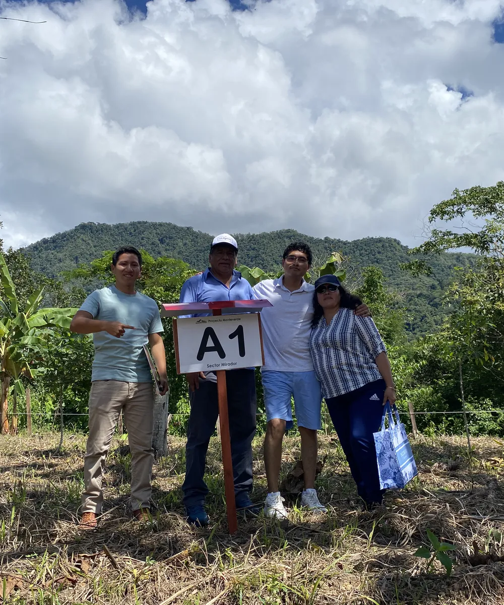 Familia de propietarios junto al cartel de su lote A1 en Monteverde